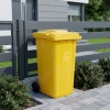 Żółty kosz na odpady ATIMA 120 l ustawiony przy posesji