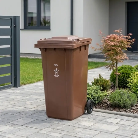 Brązowy pojemnik na bioodpady ATIMA 120 l ustawiony przy posesji